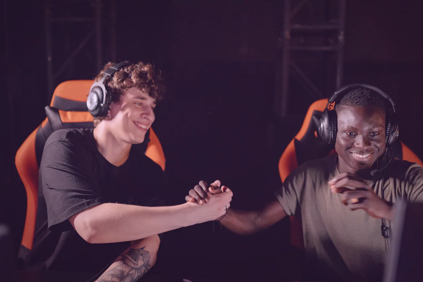 Dva hráči u stolu vysvětlují nováčkovi, jak se hraje